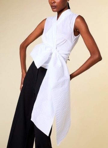 Model in weißer Bluse und schwarzer Hose